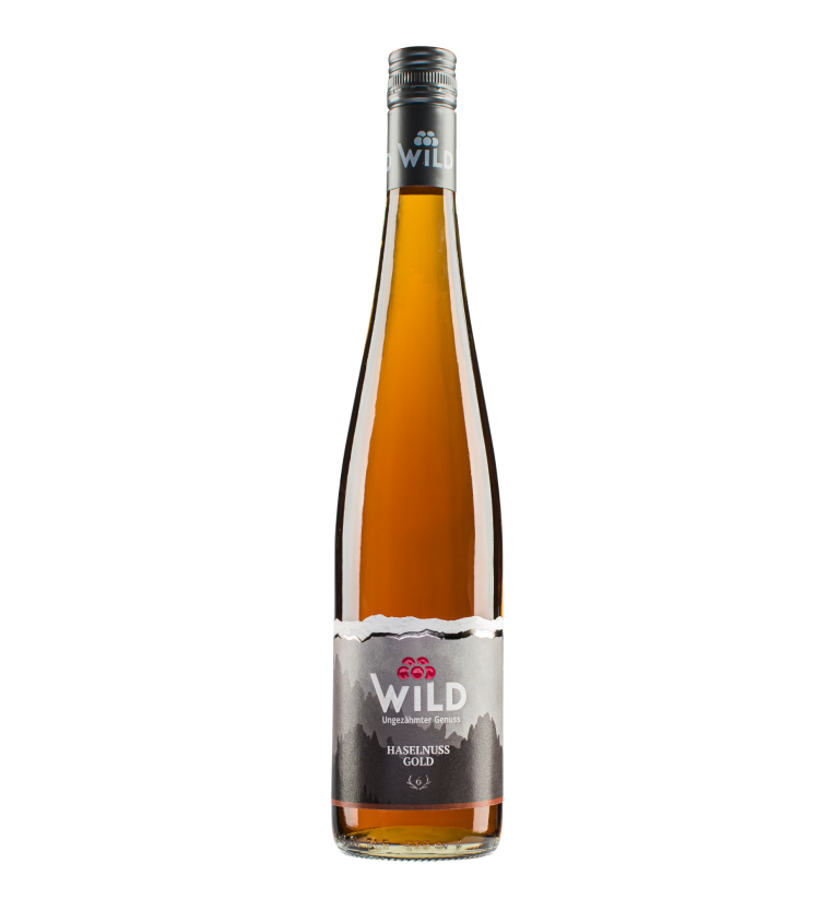 Flasche mit braunem Haselnussschnaps und ansprechend gestaltetem Etikett. Brennerei Wild, 6-Ender, Haselnuss Gold